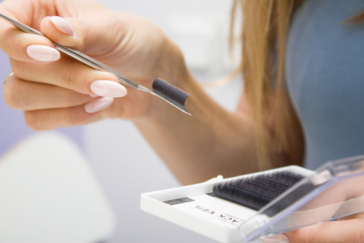 Lash tech holding extensions. Join the Cartel Lash rewards program