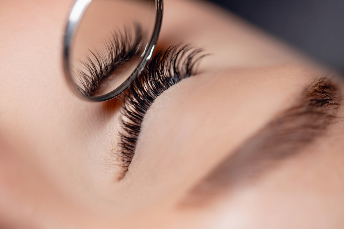 Mirror showing finished eyelash extensions on woman. Cartel Lash