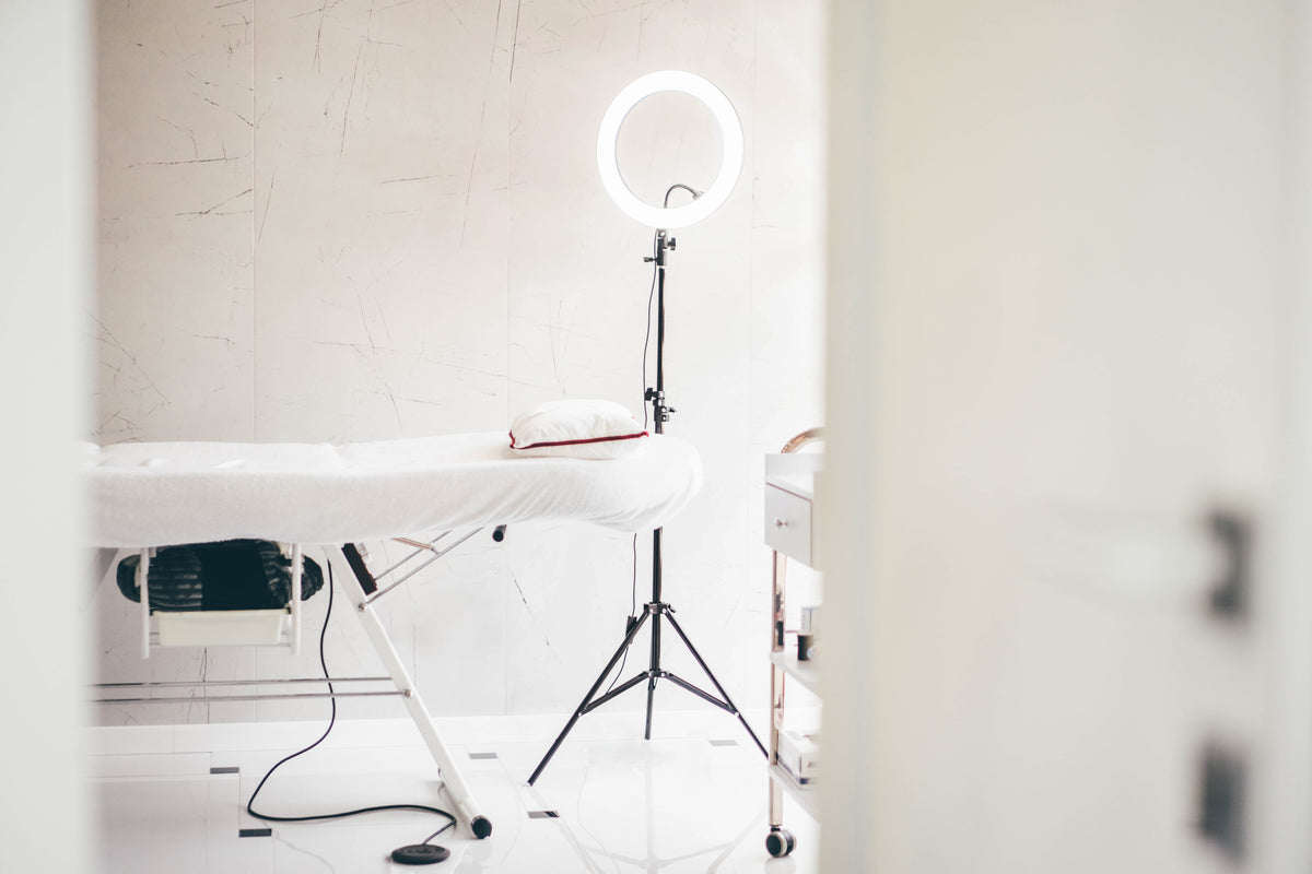 White lash bed and ring light for applying lash extensions. Cartel Lash