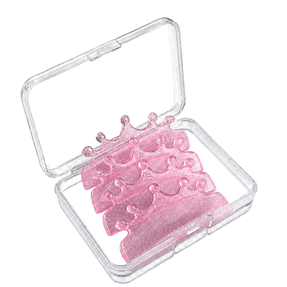 Five pink glitter crown-shaped lash lift shields arranged inside a clear plastic storage case, shown on a white background.