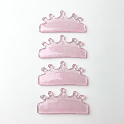 Four pink glitter crown-shaped lash lift shields arranged vertically on a plain white background