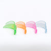 Four translucent curved lash lift sheildsin green, orange, pink, and light blue, arranged in a row on a clean white background.